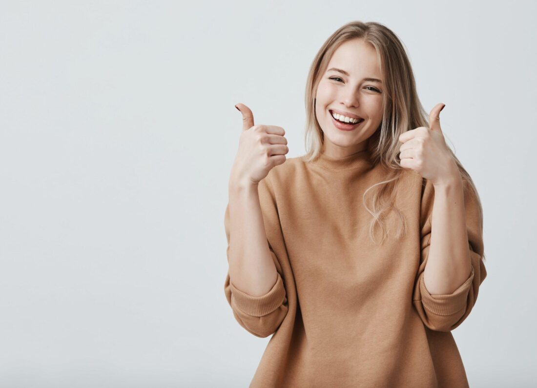 Cliente souriante levant les pouces, symbole de satisfaction